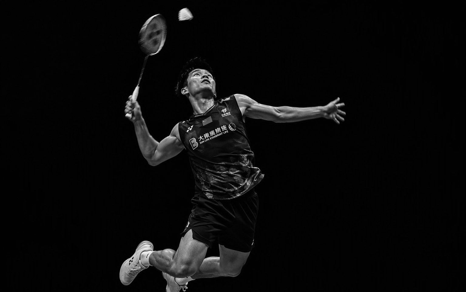 A badminton player mid-smash